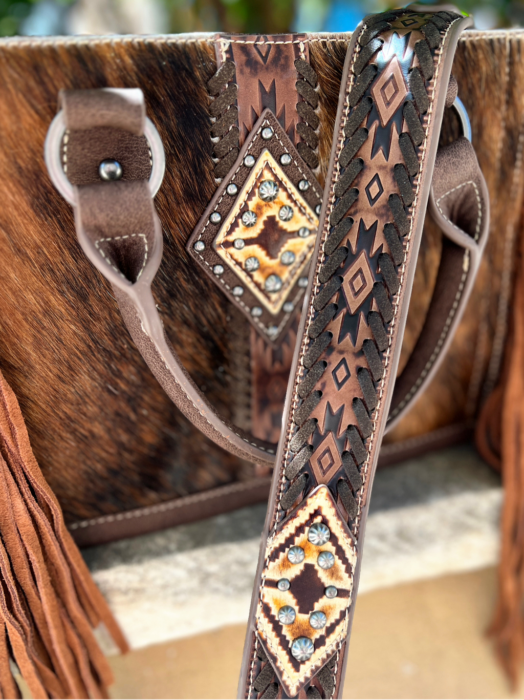 Wrangler Cuttin' Across A Pasture Cowhide Bag I Gussied Up Online. leather. hair on hide. brindle. brown leather. tooled leather. fringe detail. nail head accents. Small business. Women's western Boutique. Ships fast from Texas. 